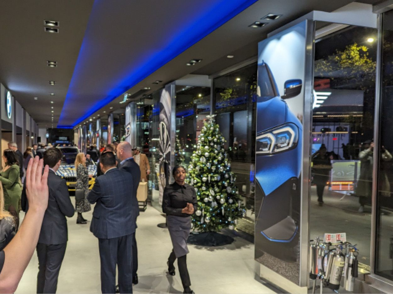 A BMW launch event in the Park Lane showroom, guests photographing a car under blue light