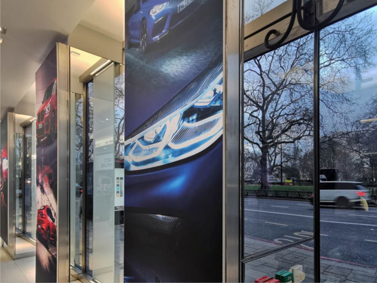 Full-height pillar graphics along the showroom glazing.